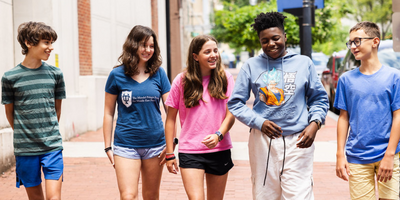 students from a DC public charter school walking down a sunny street sidewalk